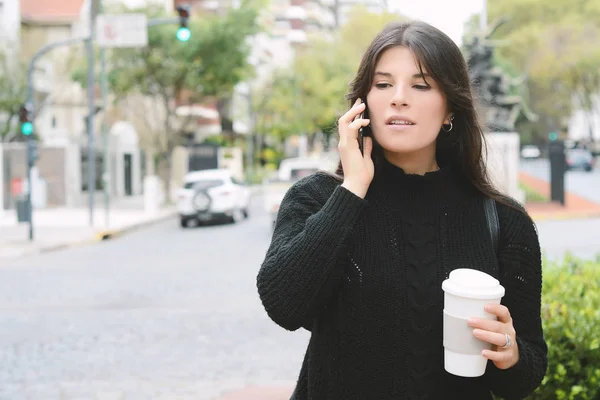 美丽的女人喝着纸杯咖啡 在冬日大街上用她的手机 Concep — 图库照片