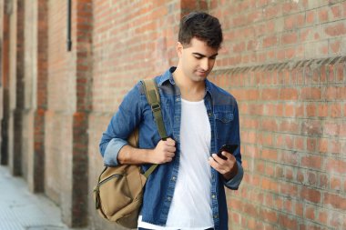 Telefonunda daktilo eden genç Latin adamın portresi. Açık havada..