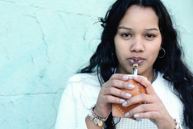 Geleneksel Arjantin yerba mate çay içme genç latin kadın portresi. Güney Amerika popüler içecek. Açık havada