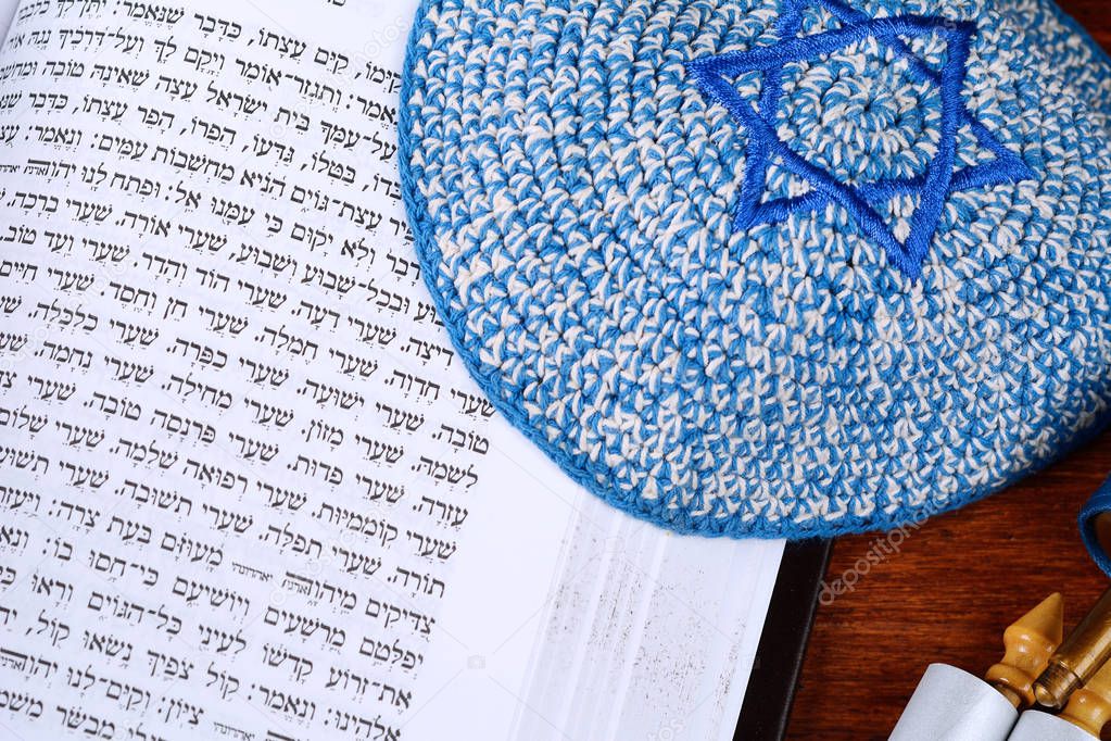 Torah with kippah on wooden background. Jewish religion concept 