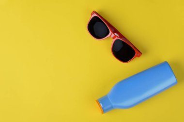 Üstten Görünüm güneş gözlüğü, kabukları, deniz yıldızı ve güneş kremi ile boşaltmak. Yaz konsepti. Açık mavi renkli 