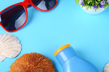 Üstten görünüm güneş gözlüğü, kabukları, deniz yıldızı ve güneş kremi. Yaz konsepti.