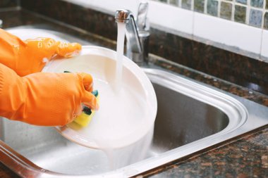 Sünger ile bulaşık eldivenleri elinde yakından görmek. Ev kavramı