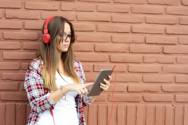 Onun tablet kullanarak güzel genç bir kadın portresi. Açık havada. Kentsel sahne.