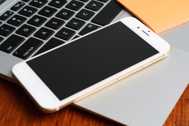 Ahşap masa üzerinde klavye ve telefon ile siyah ekran görünümünü kapatın. Teknoloji kavramı