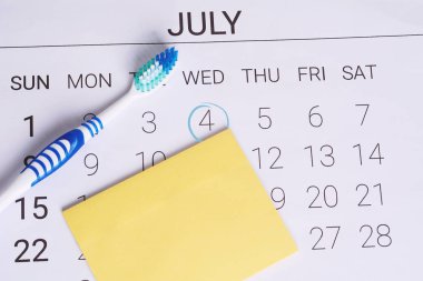 Takvim bir işaretli tarih ve diş fırçası dişçi randevu günü Temmuz ayında hatırlatmak için. Dişlerle ilgili sağlık bilgisi ve sağlıklı kavramı.