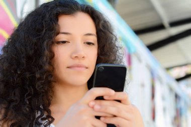 güzel genç latin kadınlar sokakta smartphone ileti gönderme.