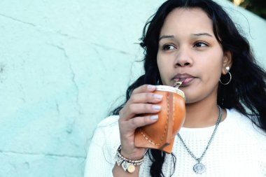 Geleneksel Arjantin yerba mate çay içme genç latin kadın portresi. Güney Amerika popüler içecek. Açık havada