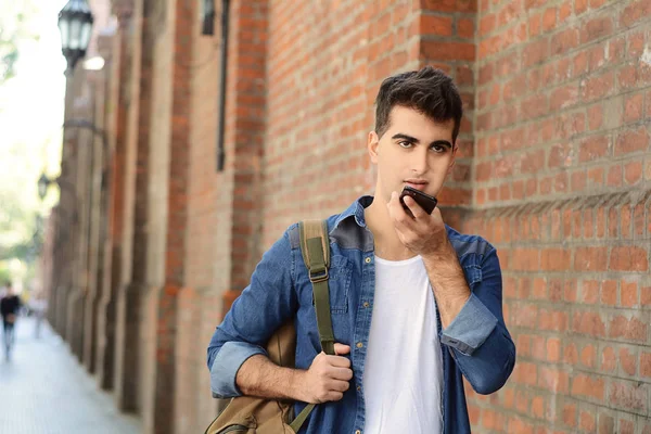 Sesli mesaj gönderme genç latin adam portresi. Açık havada. Kentsel sahne.