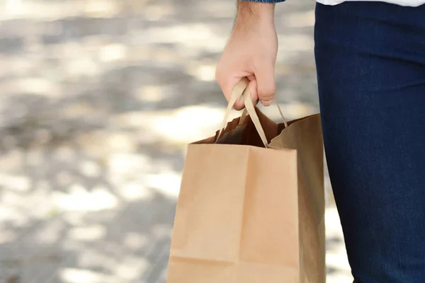男の手は屋外ショッピング バッグを保持しています ショッピングの人 消費とライフ スタイルのコンセプト — ストック写真