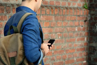 Telefonunda daktilo eden genç Latin adamın portresi. Açık havada..