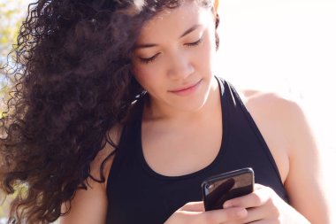 güzel genç latin kadınlar sokakta smartphone ileti gönderme.