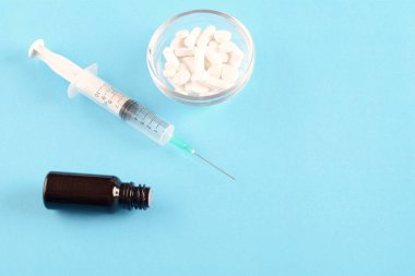 İğne ile uyuşturucu hap görünümünü kapatın. Açık mavi renkli. Uyuşturucu bağımlılığı kavramı.