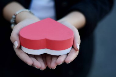 Kalp şeklinde hediye kutusu tutan eller atış kadar kapatın. Sevgililer günü, romantizm kavramı. 