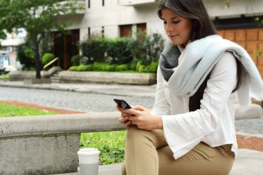 güzel genç kadın sokakta smartphone ileti gönderme.