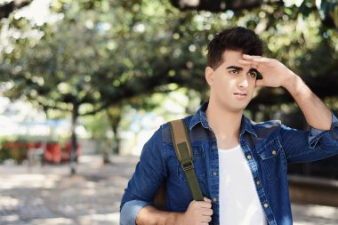 Çok uzaklara bakarak, bir şey ararken genç adam. Açık havada