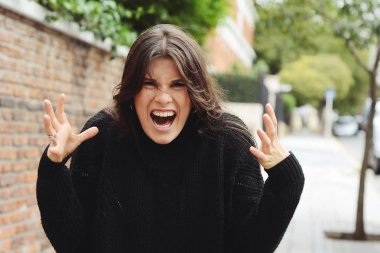 Tuğla wal karşı öfke ile çığlık Öfkeli Öfkeli kadın