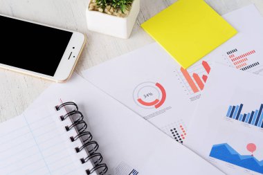 Telefonu, akıllı telefon, spiral Not defteri ve finansal kağıtları ile harita ve numaraları kapatın. İş kavramı