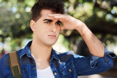 Çok uzaklara bakarak, bir şey ararken genç adam. Açık havada