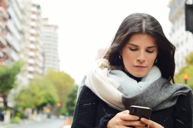 güzel genç kadın sokakta smartphone ileti gönderme.