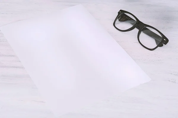 Lege Papier Met Een Bril Witte Houten Achtergrond — Stockfoto