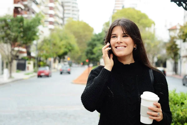 年轻的拉丁妇女的肖像与她的手机和咖啡杯 — 图库照片