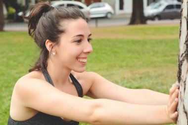 Portrair Park'ta egzersiz yaparak genç güzel kadın. Spor kavram. Açık havada