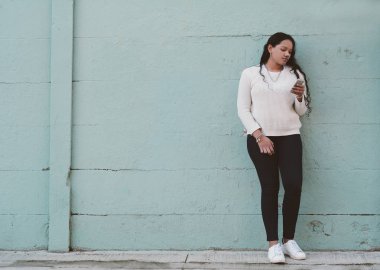 güzel genç latin kadınlar sokakta smartphone ileti gönderme.