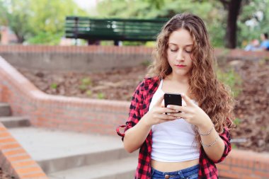 güzel genç kadın sokakta smartphone ileti gönderme.