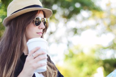 Kağıt kahve Kupası sokakta tutan güzel kadın portresi. Kentsel şehir sahne. Açık havada