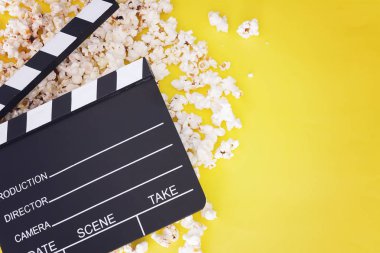 Lezzetli patlamış mısır ve fıçı tahtası sarı ahşap zemin üzerinde. Sinema kavramı