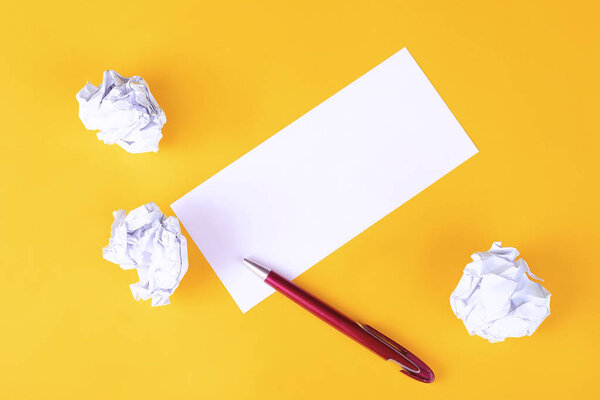 Пустая бумага с мятыми бумажными шариками на желтом фоне. Принято. Концепция мозгового штурма
