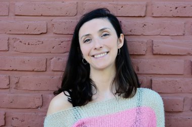 Genç kadın kış portre bir tuğla duvara. Şık kış giysileri giyen Bayan. 