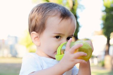 şirin bebek çocuk içme süt şişesi bir parkta