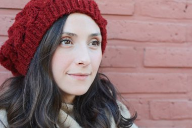 Genç kadın kış portre bir tuğla duvara. Şık kış giysileri giyen Bayan. 