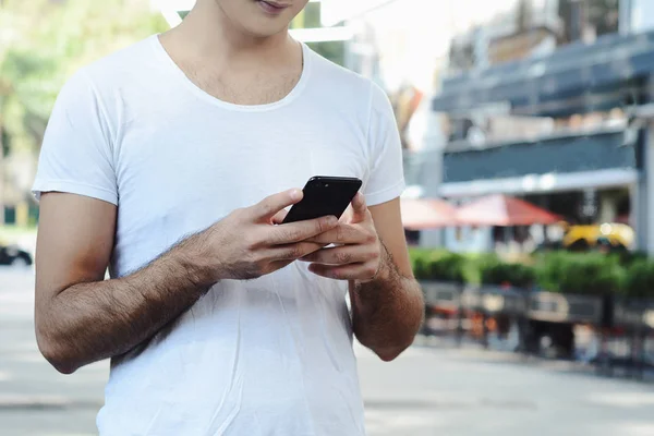 Egy Fiatal Latin Férfi Portréja Amint Gépel Telefonján Szabadtéri — Stock Fotó