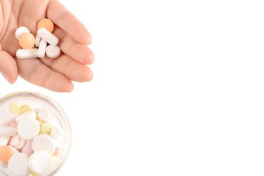 Kadın eli gösteren hap ve renkli hapları boşaltmak kase görünümünü kapatın. İzole beyaz arka plan