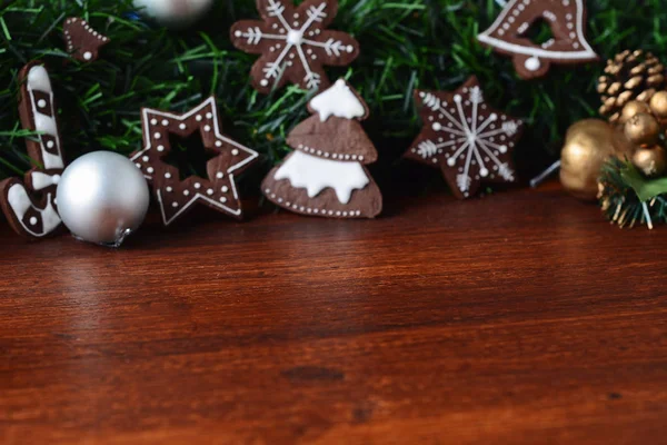 クリスマス クッキーのお祭り枝 Fir の下に掛かっている木製のテーブルのビューを閉じます クリスマス休暇の概念 — ストック写真