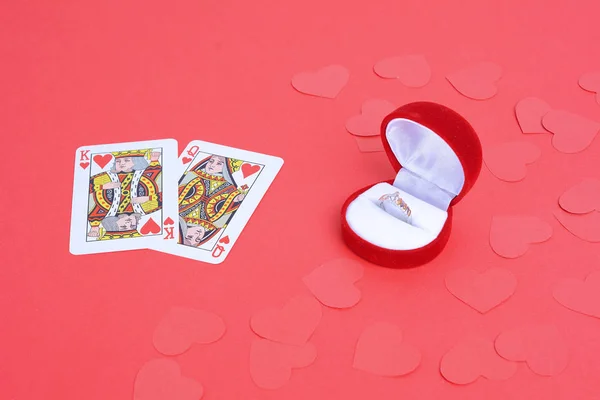 King and Queen of hearts with wedding ring in red box on red background. Valentine\'s Day concept