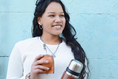 Geleneksel Arjantin yerba mate çay içme genç latin kadın portresi. Güney Amerika popüler içecek. Açık havada