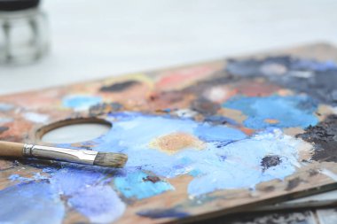 Sanatçının renkli yağlı boya konturları ve Boya fırçaları ahşap arka plan üzerinde paletle. Sanat kavramı