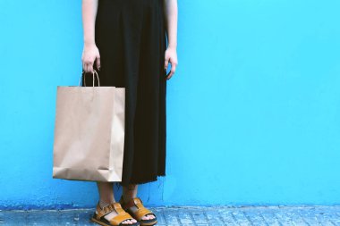 Renkli bir kentsel duvara alışveriş torbaları ile yürüyen genç kadın görünümünü kapatın. Alışveriş concep
