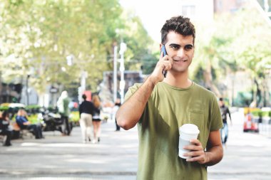 Arapça delikanlı cep telefonu ve kahve içme. Açık havada