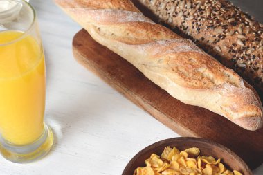 Tahıl, portakal suyu ve tost Beyaz ahşap zemin üzerinde kase ile sağlıklı kahvaltı