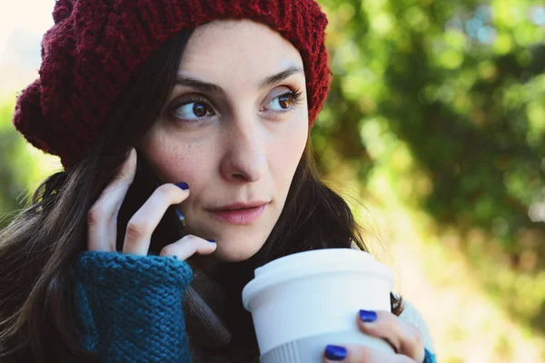一个漂亮女人的肖像 在手机上打电话 拿着一杯咖啡 冬季肖像 — 图库照片