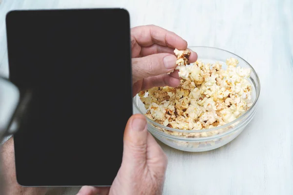 Popcorn in bowl and tablet wth black screen. Entertainment concept