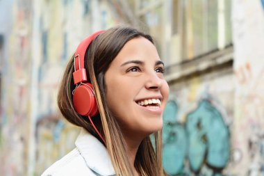 Bir grafiti duvara kırmızı kulaklık olan latin kadın portresi.