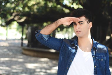 Çok uzaklara bakarak, bir şey ararken genç adam. Açık havada