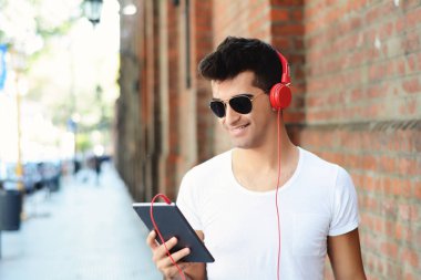 Genç latin adam tablet Street, çok dokunaklı. Kentsel kavramı.