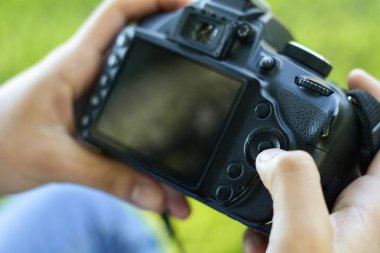 Genç latin kadın fotoğraf makinesi parkta bakarak. Çalışan profesyonel kadın. Açık havada